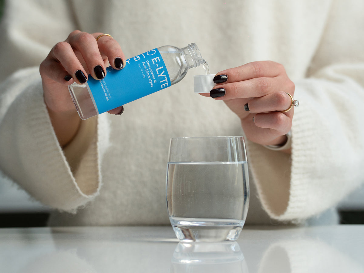 Person pouring water from a Delly bottle into a glass.