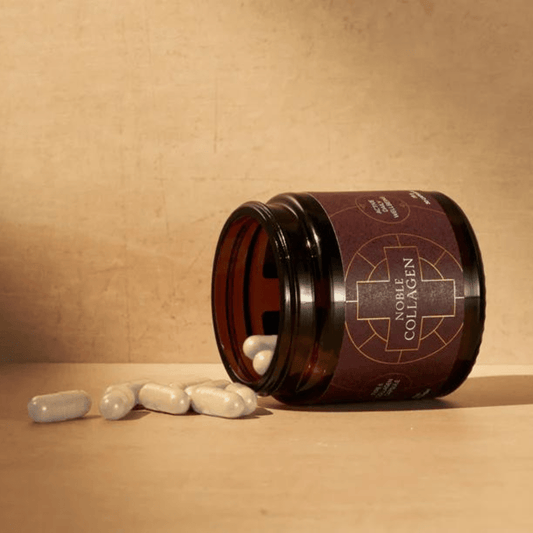 A dark jar tipped over with white capsules spilling out.