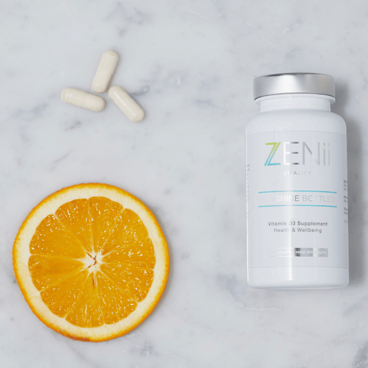 A bottle of Zen pills, a sliced orange, and three capsules.