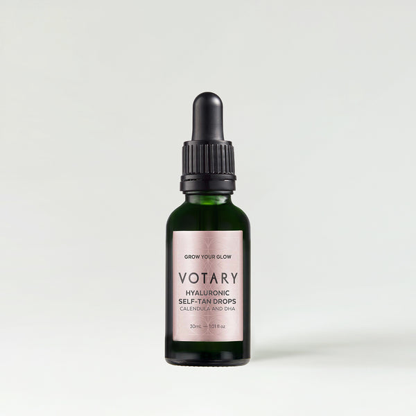 A green glass dropper bottle labelled Votary Night Oil.